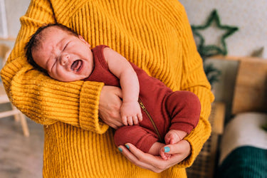 Mutterhände stützen ein Baby